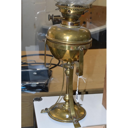 528 - AN ARTS & CRAFTS BRASS AND COPPER OIL LAMP IN THE STYLE OF W.A.S. BENSON, the frilled green and clea... 