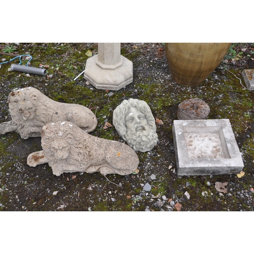 1004 - A PAIR OF COMPOSITE RECLINED GARDEN LIONS, length 72cm, along with a composite Zeus head figure, etc... 