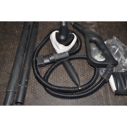 1093 - AN UNBRANDED STEAM CLEANER, with accessories (condition report: turned on but untested)