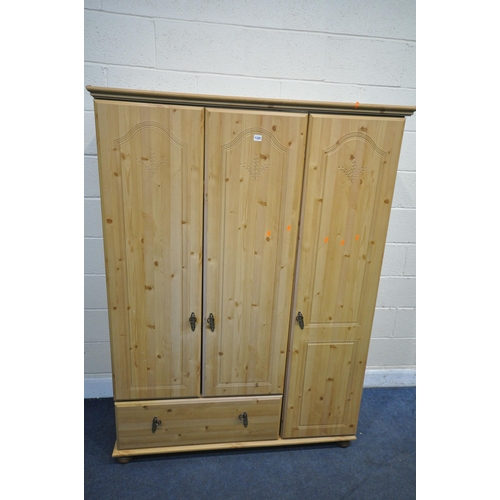 1325 - A MODERN PINE EFFECT THREE DOOR WARDROBE, with a single drawer, width 134cm x depth 53cm x height 18... 