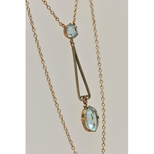 14 - AN EARLY 20TH CENTURY YELLOW METAL PENDANT NECKLACE, the drop pendant set with a pale blue oval cut ... 