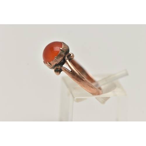 19 - A ROSE METAL CARNELIAN RING, set with a circular cut carnelian cabochon, claw set, bifurcated scroll... 