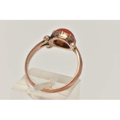 19 - A ROSE METAL CARNELIAN RING, set with a circular cut carnelian cabochon, claw set, bifurcated scroll... 