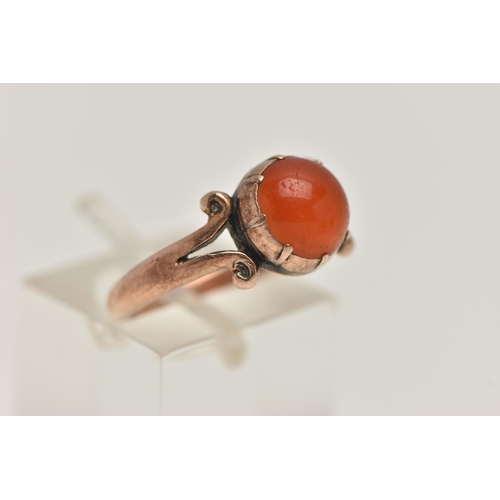 19 - A ROSE METAL CARNELIAN RING, set with a circular cut carnelian cabochon, claw set, bifurcated scroll... 