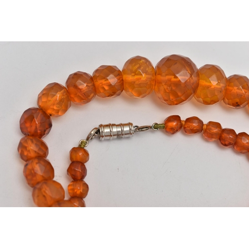 29 - A GRADUATED FACETED COPAL AMBER BEAD NECKLACE, fitted with a white metal magnetic clasp, length 440m... 