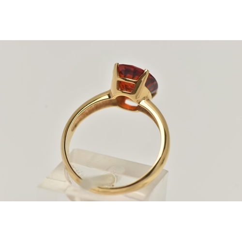 82 - A GEM SET RING, oval cut orange stone, assessed as spessartine garnet, prong set in yellow metal, st... 