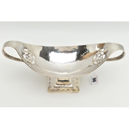 96 - A GEORGE V PLANISHED SILVER ARTS AND CRAFTS TWIN HANDLED OVAL PEDESTAL BOWL, the elongated scroll ha... 