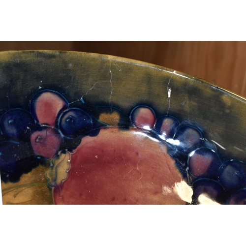 356 - A WILLIAM MOORCROFT SHALLOW FRUIT BOWL DECORATED WITH THE POMEGRANATE PATTERN ON A BLUE / BROWN GREE... 