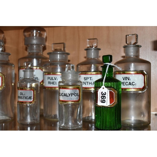 369 - A COLLECTION OF ELEVEN CLEAR AND COLOURED PHARMACY BOTTLES, all with glass labels and glass stoppers... 