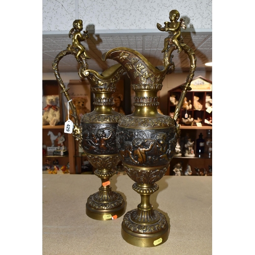 429 - A PAIR OF BRONZED BRASS EWERS, decorated with a bacchanalian design, Putti and grapevine, height 59c... 