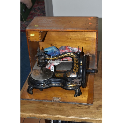 565 - A CASED JONES HAND SEWING MACHINE, swan neck, in black with rubbed gilt decoration, some paint loss ... 