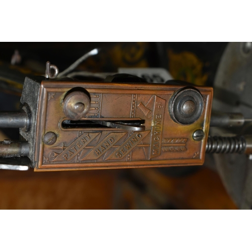 565 - A CASED JONES HAND SEWING MACHINE, swan neck, in black with rubbed gilt decoration, some paint loss ... 