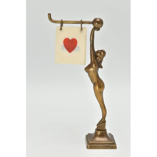 120A - AN ART DECO BRASS FEMALE NUDE BRIDGE MARKER, the figure holding a bar with five double sided suits /... 