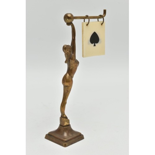 120A - AN ART DECO BRASS FEMALE NUDE BRIDGE MARKER, the figure holding a bar with five double sided suits /... 