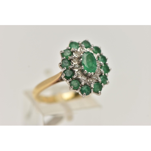 24 - AN 18CT GOLD EMERALD AND DIAMOND CLUSTER RING, oval cluster set with a central oval cut emerald, in ... 