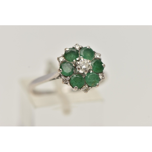 27 - A WHITE METAL EMERALD AND DIAMOND CLUSTER RING, circular cluster, set with a central raised round br... 