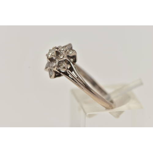 28 - A WHITE METAL DIAMOND CLUSTER RING, of a flower shape, set with a central round brilliant cut diamon... 