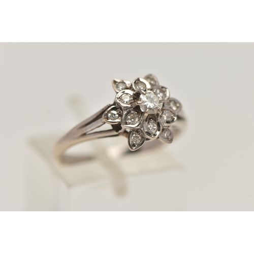 28 - A WHITE METAL DIAMOND CLUSTER RING, of a flower shape, set with a central round brilliant cut diamon... 