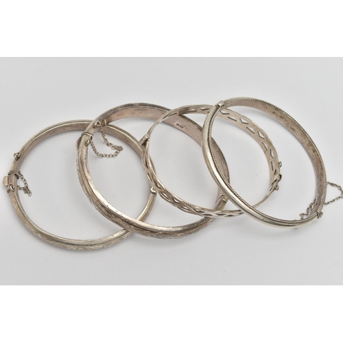 57 - FOUR SILVER HINGED BANGLES, to include two hollow hinged bangles, engraved with foliage detail, a ho... 