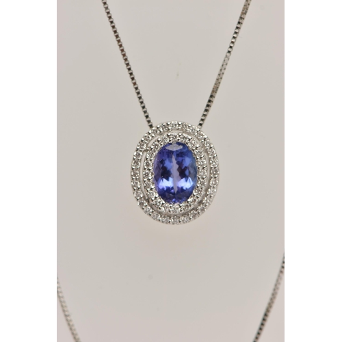 99 - AN 18CT WHITE GOLD, TANZANITE AND DIAMOND CLUSTER PENDANT NECKLACE, the pendant of an oval form, set... 