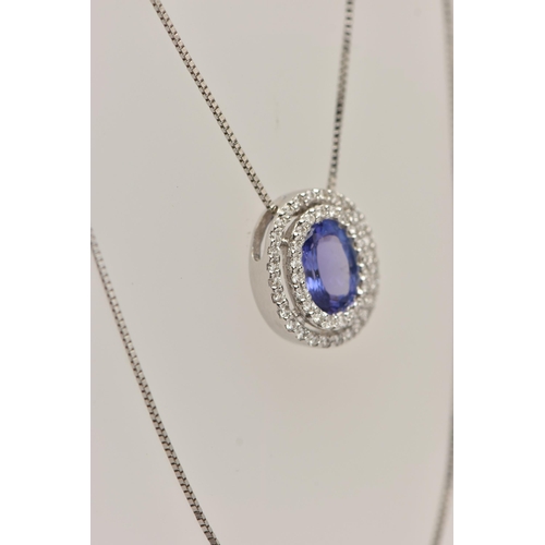 99 - AN 18CT WHITE GOLD, TANZANITE AND DIAMOND CLUSTER PENDANT NECKLACE, the pendant of an oval form, set... 