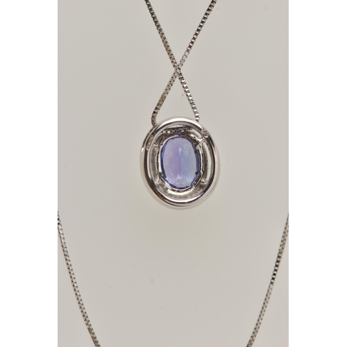 99 - AN 18CT WHITE GOLD, TANZANITE AND DIAMOND CLUSTER PENDANT NECKLACE, the pendant of an oval form, set... 