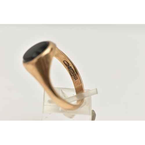 137 - A 9CT GOLD SIGNET RING, of an oval form, set with a polished onyx inlay (AF chipped), to a polished ... 