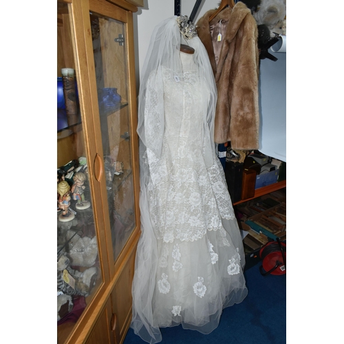 361 - A 1970S IVORY WEDDING DRESS AND VEIL, comprising a layered tulle skirt and fitted bodice, Princess l... 