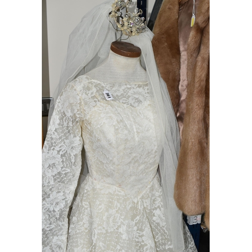 361 - A 1970S IVORY WEDDING DRESS AND VEIL, comprising a layered tulle skirt and fitted bodice, Princess l... 