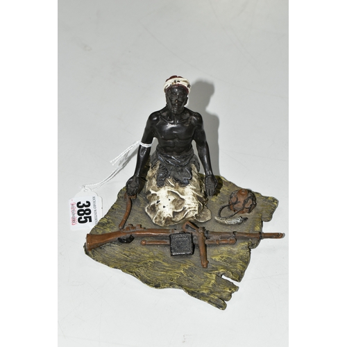 385 - A BERGMANN STYLE COLD PAINTED BRONZE OF AN ARMS DEALER, the figure kneeling on a rug with various we... 