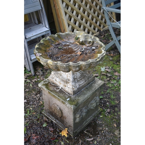 1024 - A WEATHERED COMPOSITE SHELL SHAPED BIRD BATH, on a square plinth, diameter 53cm x height 70cm (condi... 