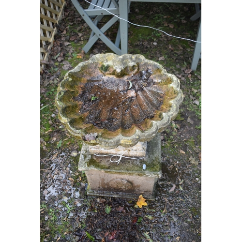 1024 - A WEATHERED COMPOSITE SHELL SHAPED BIRD BATH, on a square plinth, diameter 53cm x height 70cm (condi... 