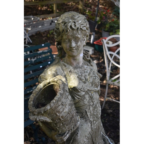 1027 - A WEATHERED COMPOSITE GARDEN STATUE, of a scantily lady carrying baskets, height 136cm (condition re... 