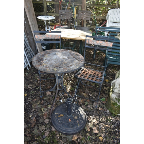 1033 - AN IRON AND TILE CIRCULAR FOLDING GARDEN TABLE, a pair of folding chairs, and a parasol stand (condi... 