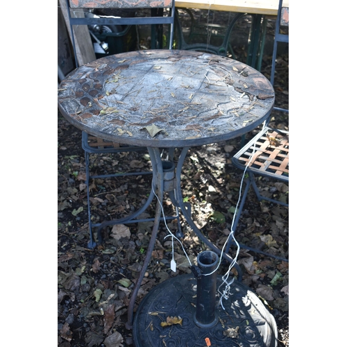 1033 - AN IRON AND TILE CIRCULAR FOLDING GARDEN TABLE, a pair of folding chairs, and a parasol stand (condi... 