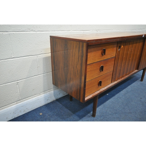 1395 - A GORDON RUSSELL ROSEWOOD SIDEBOARD, with three drawers to the left of cupboards, on circular sectio... 