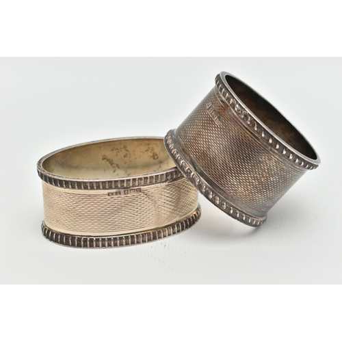 108 - TWO SILVER NAPKIN RINGS, the first of a circular form, engine turned pattern with vacant cartouche, ... 