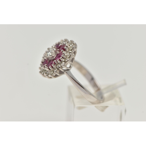 36 - A WHITE METAL RUBY AND DIAMOND CLUSTER RING, flower cluster set with a central round brilliant cut d... 