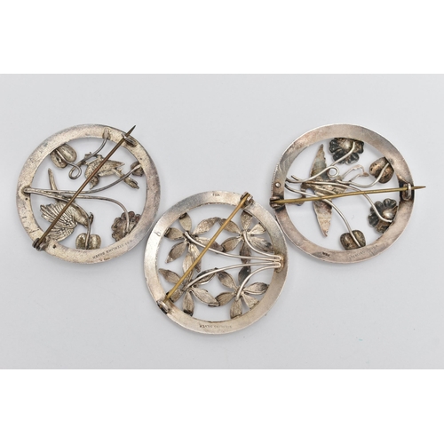 82 - THREE OPEN WORK BROOCHES, the first a circular form brooch with floral detail, an enamel detailed st... 