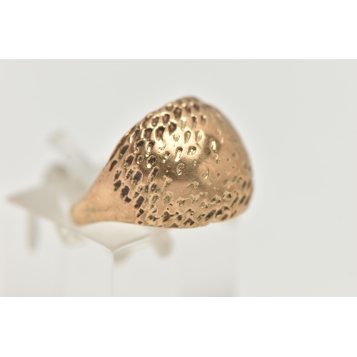 98 - A YELLOW METAL DOME RING, textured dome, to a polished band, unmarked, ring has been resized, ring s... 