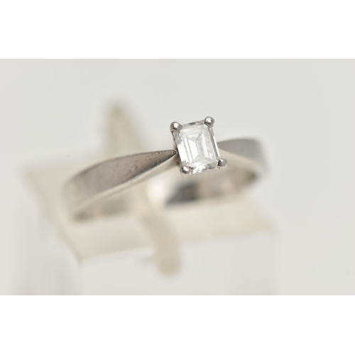 162 - A PLATINUM SINGLE STONE DIAMOND RING, emerald cut diamond prong set in platinum, leading on to a pin... 