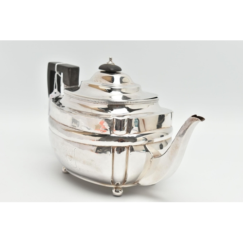 195 - A GEORGE III SILVER TEAPOT, polished form, worn engraved crests to either side, on four ball feet, f... 