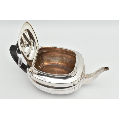 195 - A GEORGE III SILVER TEAPOT, polished form, worn engraved crests to either side, on four ball feet, f... 