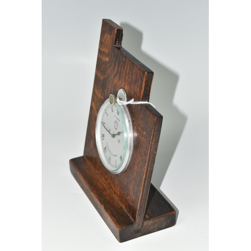 514 - A JAEGER FOUR DAY CAR CLOCK, fitted into an oak mount, the silver coloured dial having Roman numeral... 