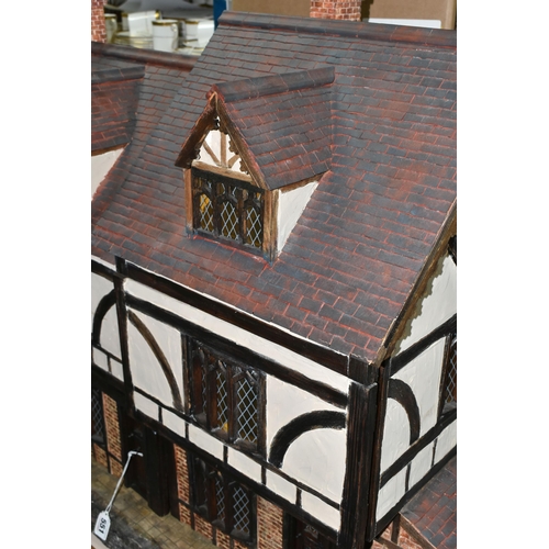 551 - A WOODEN DOLLS HOUSE, modelled as an Elizabethan style half-timbered house, front opening to reveal ... 