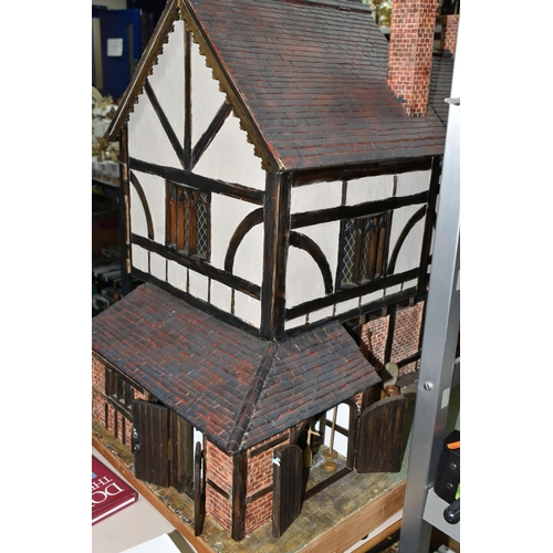 551 - A WOODEN DOLLS HOUSE, modelled as an Elizabethan style half-timbered house, front opening to reveal ... 