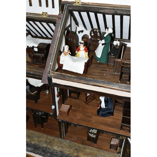 551 - A WOODEN DOLLS HOUSE, modelled as an Elizabethan style half-timbered house, front opening to reveal ... 