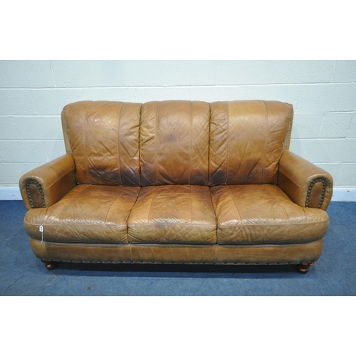 1408 - A TAN STUDDED LEATHER THREE SEATER SETTEE, length 184cm (condition report: cracks to arm rests, seat... 