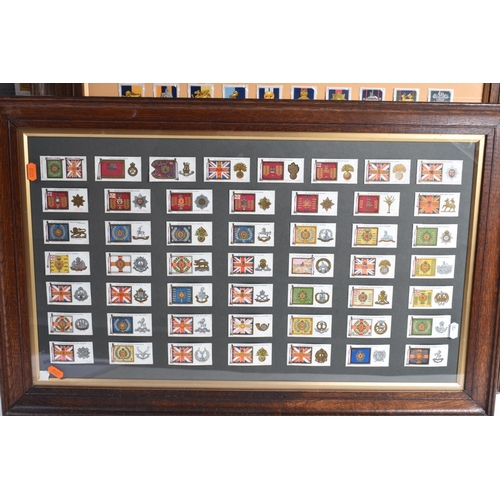 473 - THREE FRAMED AND GLAZED DISPLAYS OF MILITARY CAP BADGES AND KINGS COLOURES, the cards include one fr... 