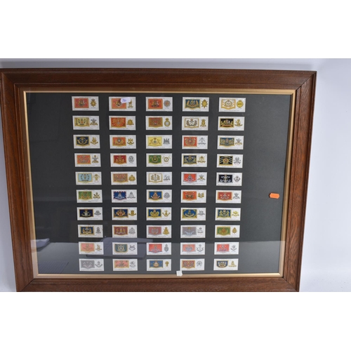 473 - THREE FRAMED AND GLAZED DISPLAYS OF MILITARY CAP BADGES AND KINGS COLOURES, the cards include one fr... 